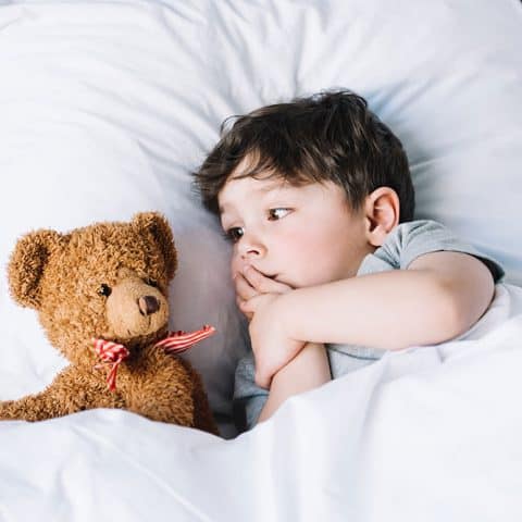 Toddler tucked into bed