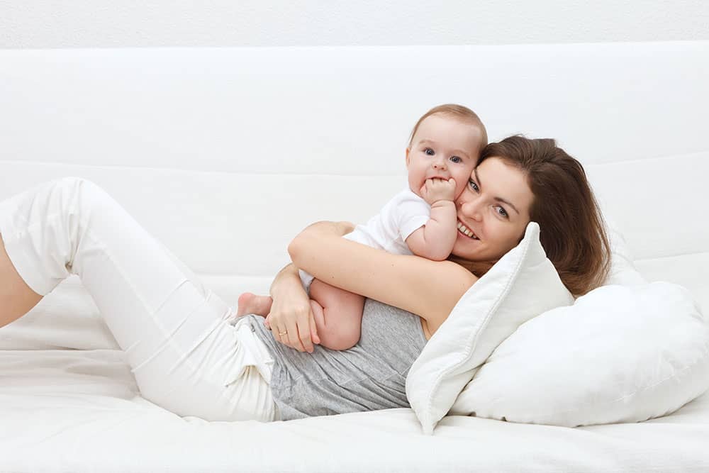 mom holding baby and practising self care after birth