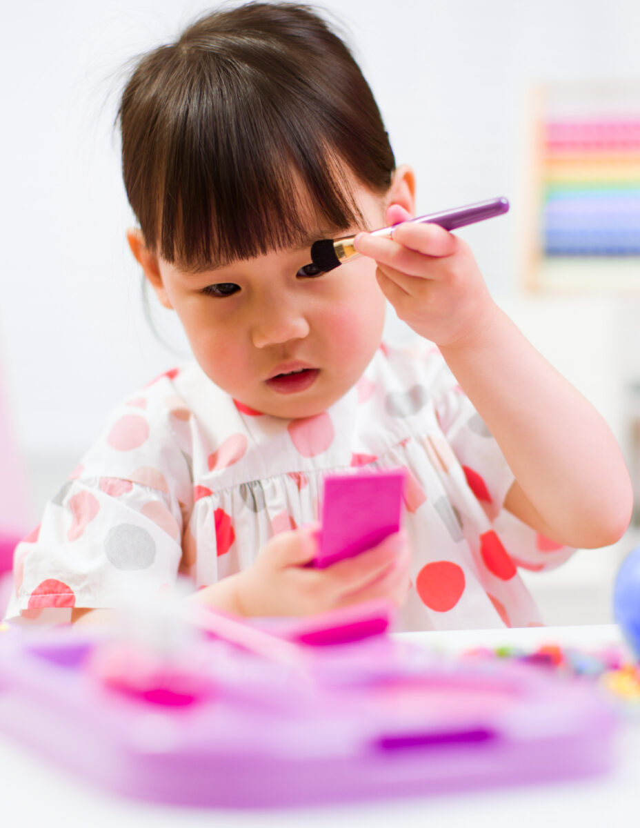 toddler playing with pretend make up